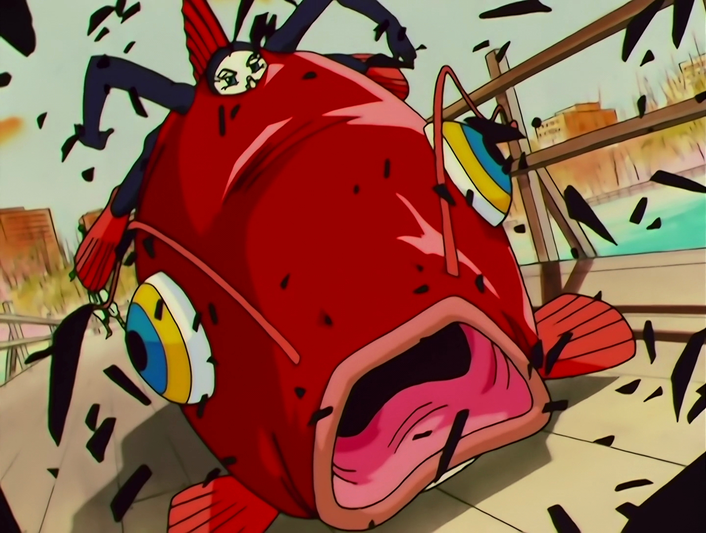 PakuPaku Yarou, a Lemures from Sailor Moon episode 159. So, there’s this guy. And he’s got a very pale white face, and he’s wearing a black bodysuit and red flippers, and he’s wedged into the back of a giant red fish. He’s just lying flat on his stomach and it’s like he’s partially phased into this fish. The fish is currently destroying a boardwalk.